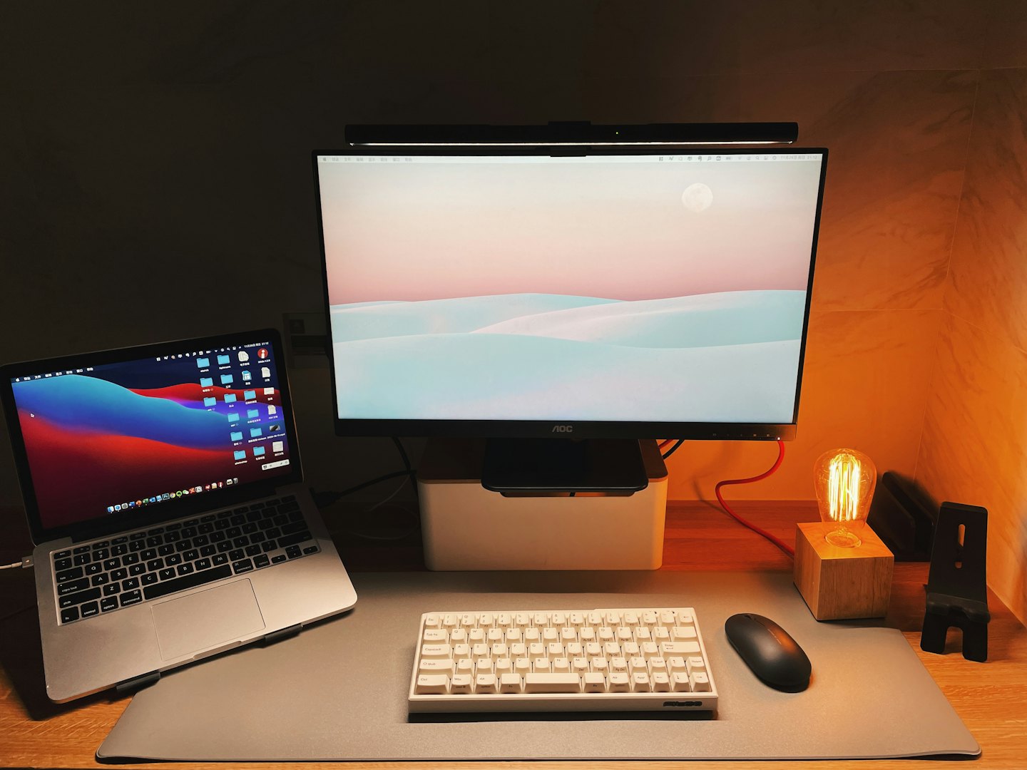 A laptop and monitor sit on a wooden office desk.