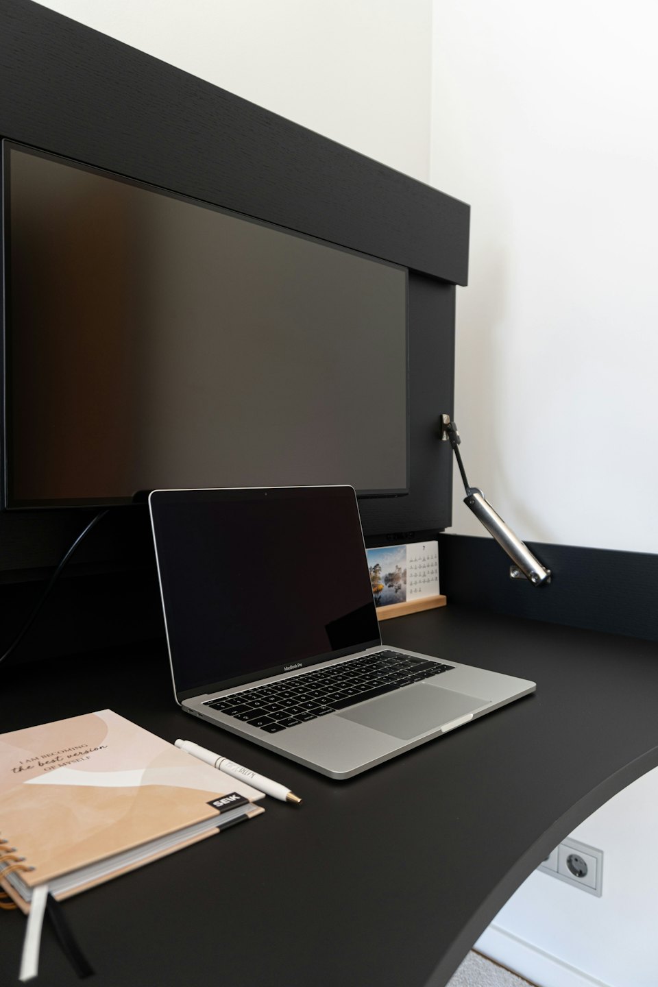 Laptop and notebook on a modern home office desk.